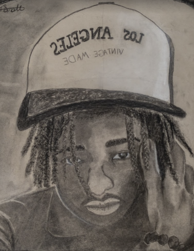 charcoal on paper drawing of a high school student wearing a baseball cap with braids that peak out from under the hat. The student is wearing a collared shirt and has one hand up touching the side of their face.